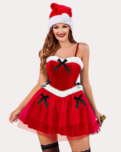 Green velvet Santa bustier dress with bows, sheer layered skirt, and festive hat.